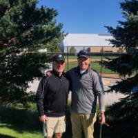 Two alumnus pose for a photo at the golf outing